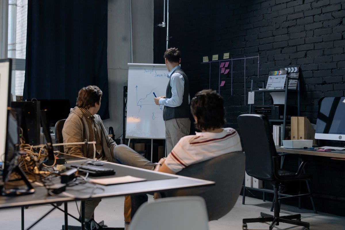 Reunião de trabalho diante de um quadro branco com gráficos